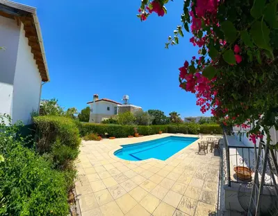 a backyard with a swimming pool and a house at Villa NATURA in Strovolos