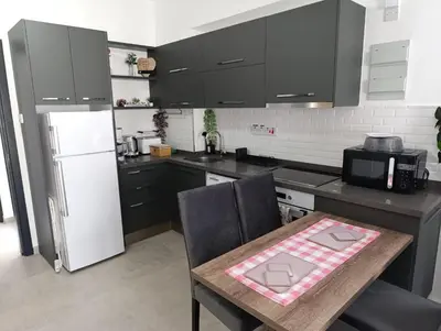 a kitchen with a table and a white refrigerator at Deja Blue Apartments, North Cyprus