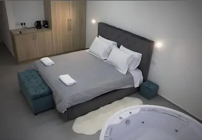 a small bedroom with a bed and a bath tub at Plateia Suite Deluxe in Nicosia