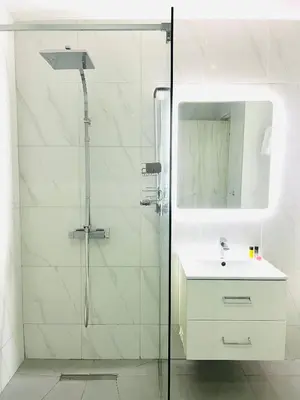 a bathroom with a sink and a glass shower at Plateia Suite Deluxe in Nicosia