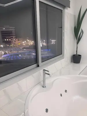 a bathroom with a white sink and a window at Plateia Suite Deluxe in Nicosia