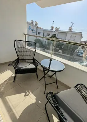 a balcony with two chairs and a table and a window at Bachelor Court 1 in Ayia Napa