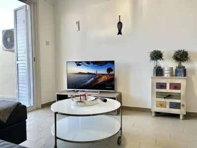 a living room with a table and a tv at STAY Almyra House in Protaras