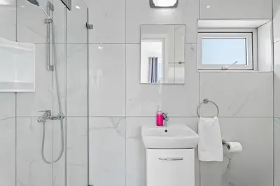 a white bathroom with a shower and a sink at Levanda Hills Haven in Protaras in Paralimni