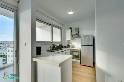 a kitchen with white counters and a stainless steel refrigerator at The lighthouse 1 bedroom 604 in Larnaka