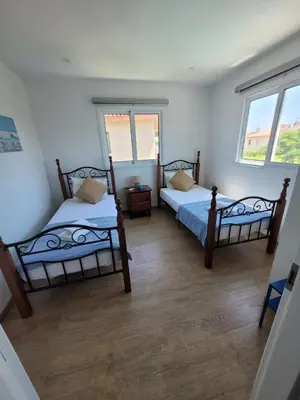 two beds in a room with two windows at Ayia Napa Marina Luxury Villas - Aquamarine in Ayia Napa