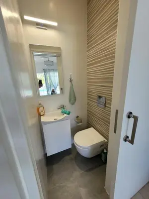 a bathroom with a toilet and a sink and a mirror at Ayia Napa Marina Luxury Villas - Aquamarine in Ayia Napa