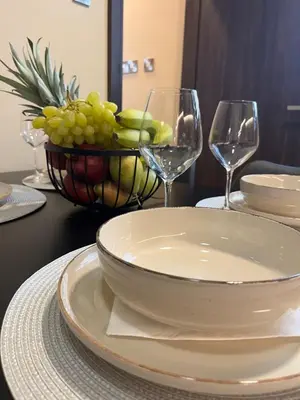 a table with a bowl of grapes and wine glasses at Oasis Penthouse Luxury Suite in Limassol