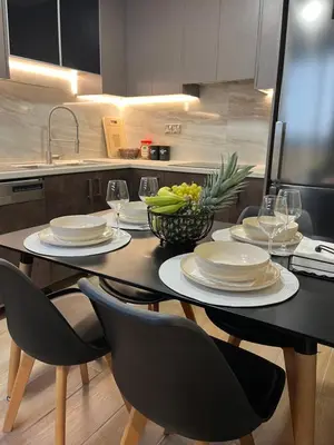 a dining room table with chairs and plates and wine glasses at Oasis Penthouse Luxury Suite in Limassol