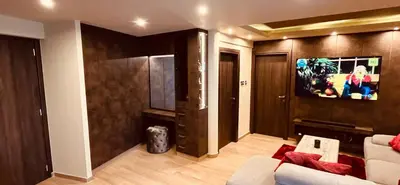 a living room with a couch and a tv on a wall at Oasis Penthouse Luxury Suite in Limassol