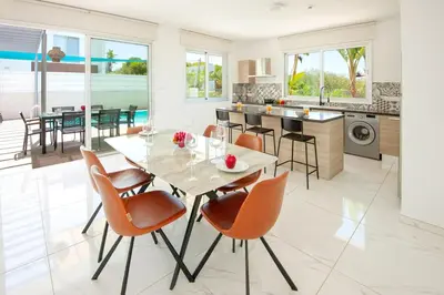 a kitchen and dining room with a glass table and chairs at Elite Panoramic View 3Bdr Villa with pool Ayia Napa in Ayia Napa