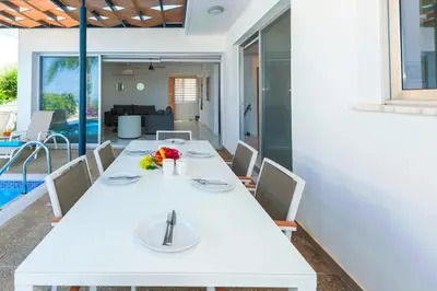a dining room with a white table and chairs at Royal Panoramic View 3Bdr Villa with pool Ayia Napa in Ayia Napa