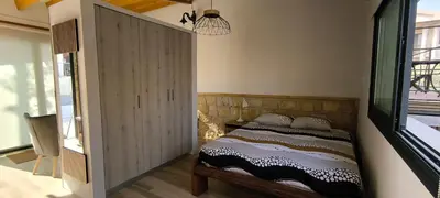 a bedroom with a bed and a large window at The Zephyr House in Pyrgos