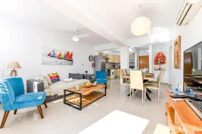 a living room with a bed and a dining room at Nissi Apartment #102 in Ayia Napa