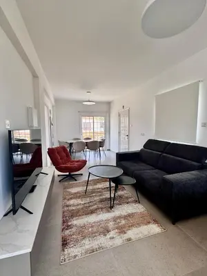 a living room with a black couch and a table at Dhekelia Beach house - Pyla, Larnaca in Pyla