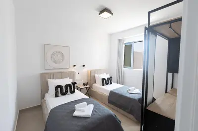 a hotel room with two beds and a mirror at Ayia Napa Orea Villa OR9 in Ayia Napa