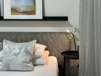 a bedroom with a bed with a pillow and a table at Modern City Apartment in Larnaka
