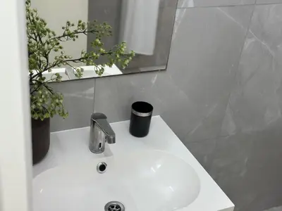 a white sink in a bathroom with a mirror at Modern City Apartment in Larnaka