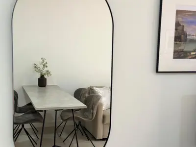 a mirror in a room with a table and a chair at Modern City Apartment in Larnaka