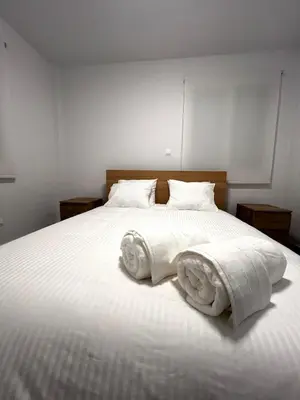 a bedroom with a white bed with towels on it at The Minimal Nest in Nicosia
