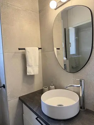 a bathroom with a white sink and a mirror at The Minimal Nest in Nicosia