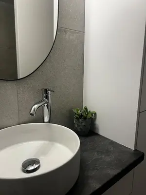 a white sink in a bathroom with a mirror at The Minimal Nest in Nicosia