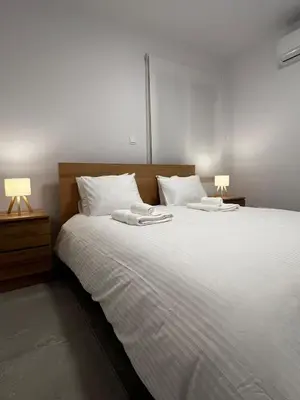 a bedroom with a large white bed with two lamps at The Minimal Nest in Nicosia