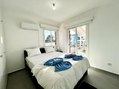 a bedroom with a bed with blue pillows on it at STAY Capari Light Apartment in Protaras