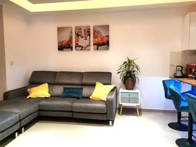 a living room with a gray couch and yellow pillows at Nestia Apartment in Yermasoyia