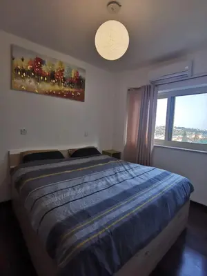 a bedroom with a large bed and a window at Nestia Apartment in Yermasoyia