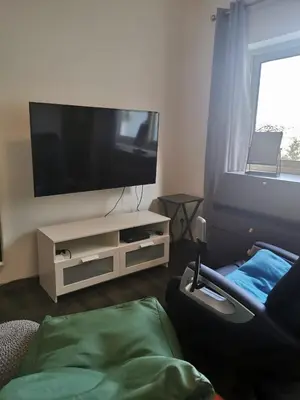 a living room with a flat screen tv and a couch at Nestia Apartment in Yermasoyia