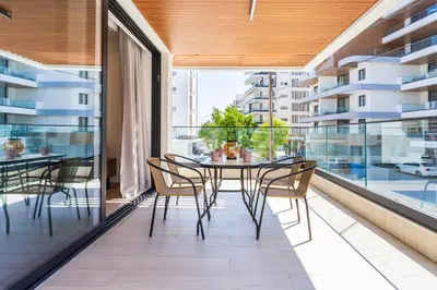 a dining room with a table and chairs on a balcony at Densho 2-Bedroom Luxury Apartment in Larnaka