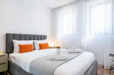 a bedroom with a large bed with orange and white pillows at Itero 2-Bedroom Luxury Apartment in Larnaka