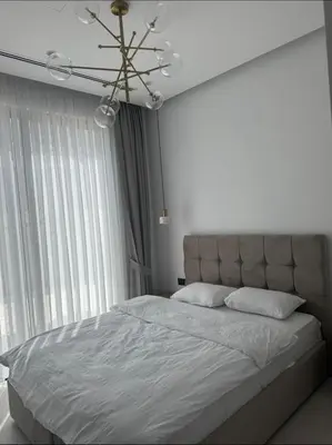 a white bedroom with a large bed and a chandelier at Mykonos Homes Villa in Aglantzia