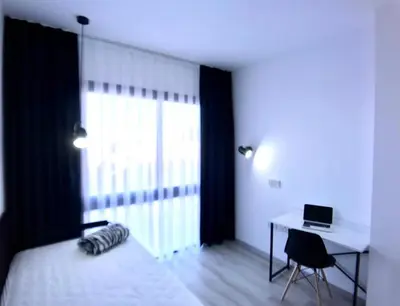 a bedroom with a bed and a desk with a laptop at Eden Garden 2 bedroom Alsancak in Nicosia International Airport