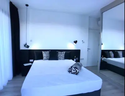 a bedroom with a large white bed and a mirror at Eden Garden 2 bedroom Alsancak in Nicosia International Airport