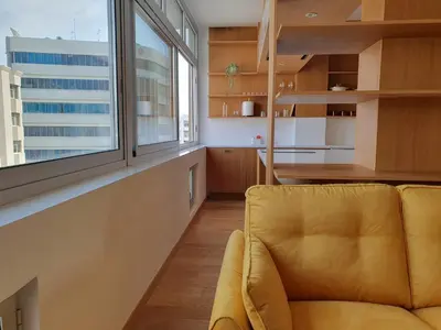 a living room with a yellow couch and a large window at The C Suite - Business & Leisure in Nicosia in Nicosia