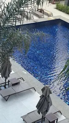 a swimming pool with two lounge chairs next to a swimming pool at Long Beach, İskele, Grand Sapphire Resort - Pool View Luxury Studio in Paralimni