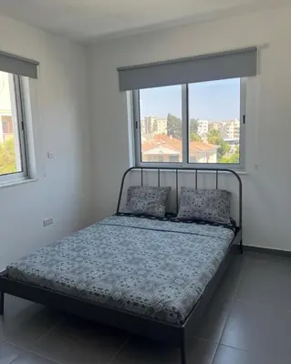 a bed in a white room with a window at Mariam Court 302 in Larnaka