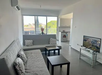 a living room with a couch and a tv in it at Mariam Court 302 in Larnaka