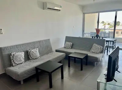 a living room with two couches and a tv at Mariam Court 302 in Larnaka