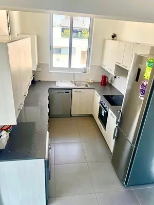a kitchen with white cabinets and a stainless steel refrigerator at Mariam Court 302 in Larnaka