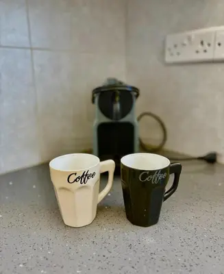 two coffee cups sitting on top of a counter at Mariam Court 302 in Larnaka