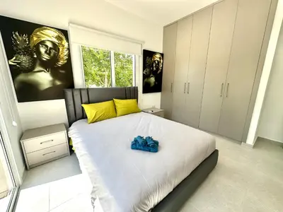 a bedroom with a large white bed with yellow pillows at Home in the Hills in Limassol