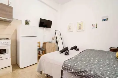 a kitchen with a white refrigerator and a bed at Сozy and traditional - EC Studios in Larnaka