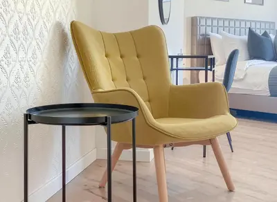 a yellow chair and a table in a room at Plateia suite Grigio in Nicosia