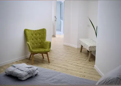 a living room with a green chair and a blanket at Plateia suite Grigio in Nicosia