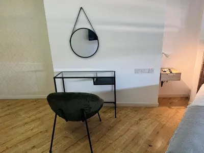 a mirror and a chair in a bedroom at Plateia suite Grigio in Nicosia