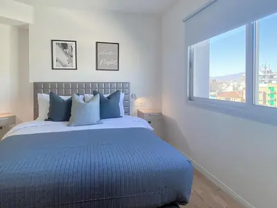 a bedroom with a bed and a large window at Plateia suite Grigio in Nicosia