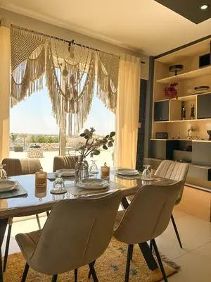 a dining room with a table and chairs and a large window at Modern Penthouse Overlooking Pool in Pyla